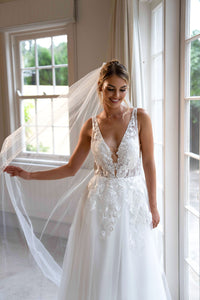 Ivory White A-line Wedding Gown with V Neckline adorned with Lace Appliques, Sheer Bodice and Full Voluminous Layered Tulle Skirt worn with White Tulle Veil