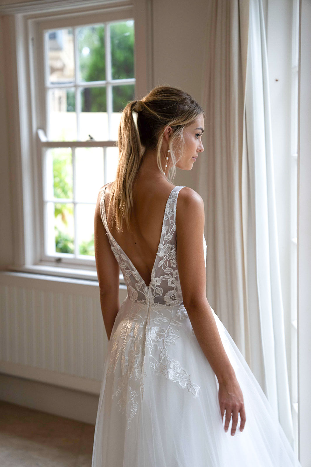 Open Back Design of Ivory White A-line Wedding Gown with V Neckline adorned with Lace Appliques, Sheer Bodice and Full Voluminous Layered Tulle Skirt