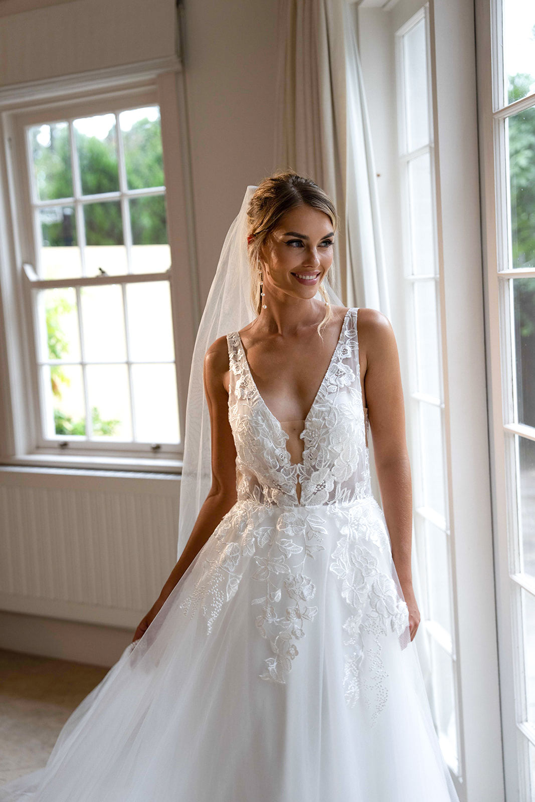 Ivory White A-line Wedding Gown with V Neckline adorned with Lace Appliques, Sheer Bodice and Full Voluminous Layered Tulle Skirt