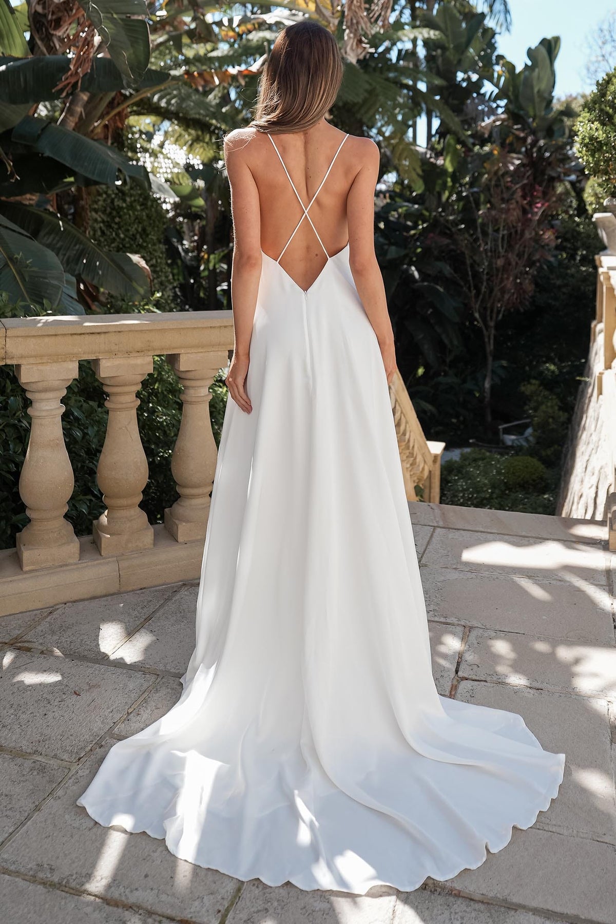 ROSITA ivory wedding dress with a low open back, delicate crisscross spaghetti straps and flowing A-line skirt with train