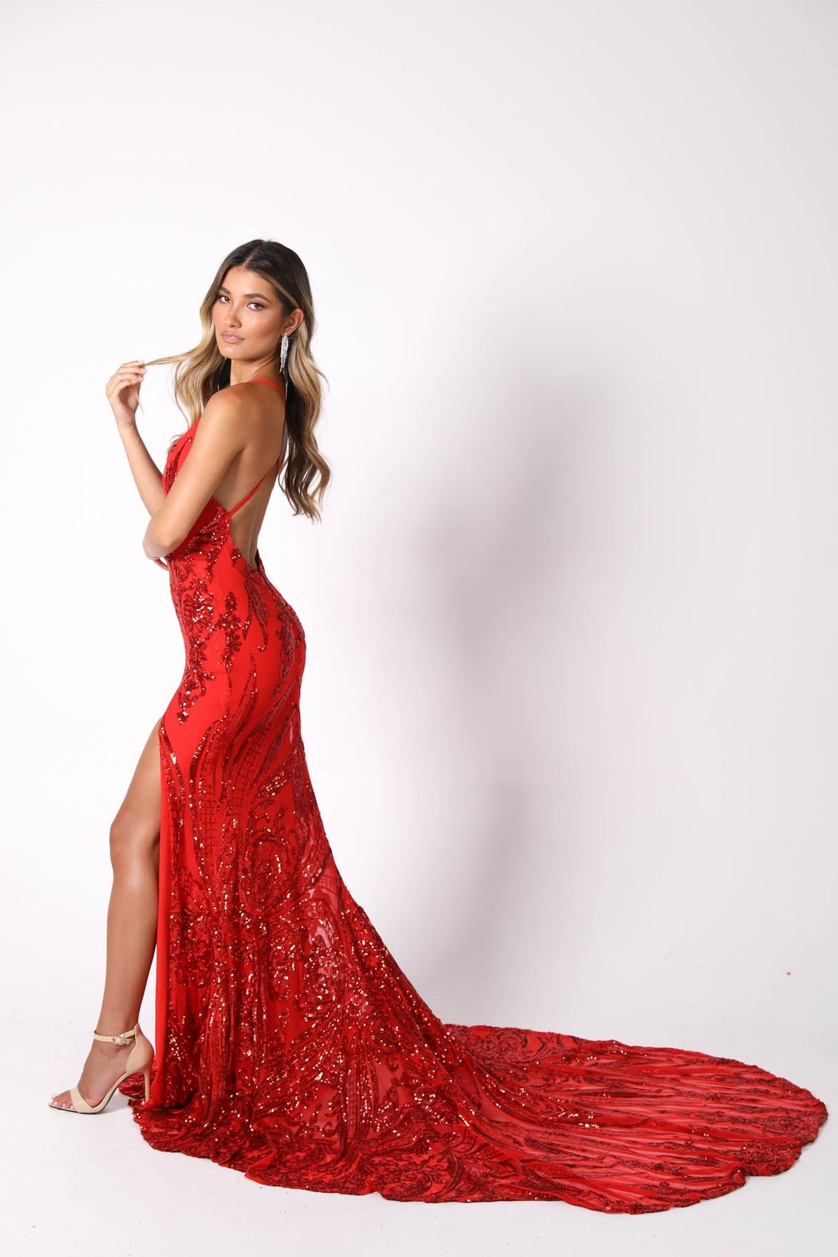 Side Sweep Train Image of Red Full Length Evening Sequin Gown with Deep Red Embroidered Pattern Sequins Over Red Underlay, V neckline, Criss-cross Straps on Open Back, Thigh-high Side Slit, Fit and Flare Silhouette