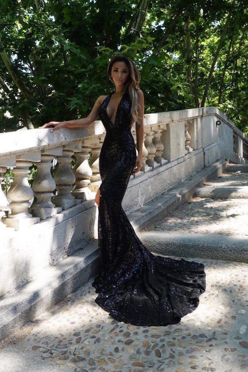 Black sleeveless sequin evening gown with very long train, deep plunging neckline, and halterneck style