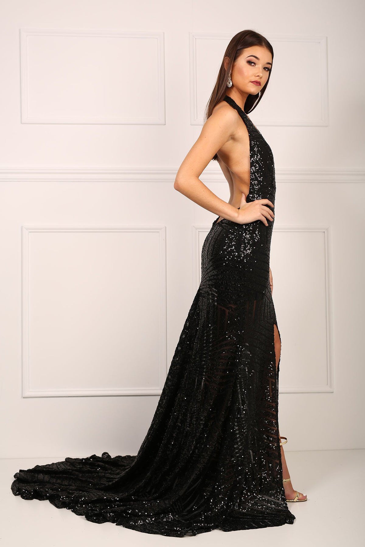Side of black sequinned mermaid evening gown with halter v plunge neck and high centre front leg slit