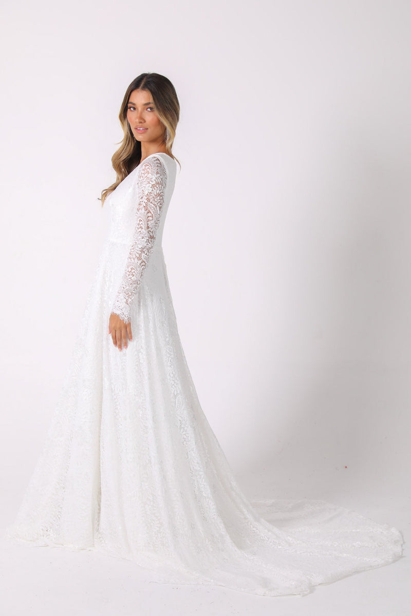 Side Image of White Long Sleeve Lace Wedding Gown with V-Neck, Sheer Lace Fitted Sleeves, A-Line Skirt and Sweep Train